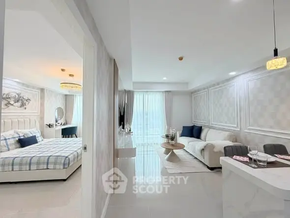 Modern open-plan living room and bedroom with elegant decor and natural light.