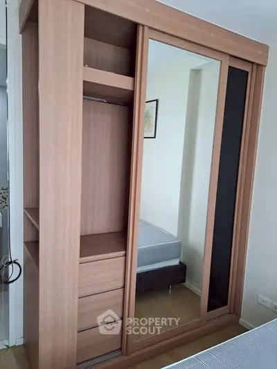 Spacious bedroom with modern wooden wardrobe and mirror sliding doors