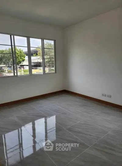 Spacious empty room with large window and glossy tiled floor, perfect for customization.