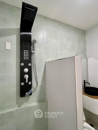 Modern bathroom with sleek shower panel and stylish sink in contemporary design.