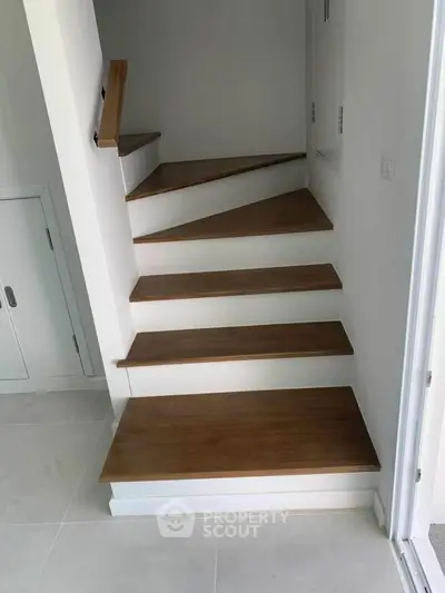 Modern wooden staircase with sleek design in a contemporary home interior.