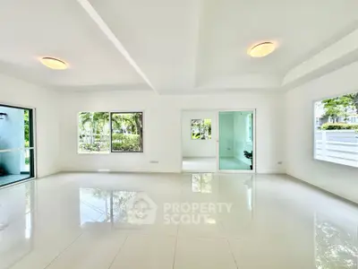 Spacious modern living room with large windows and glossy tile flooring