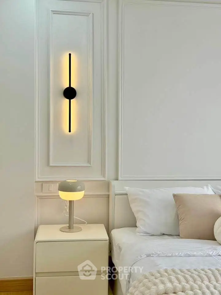 Elegant bedroom with modern lighting and cozy bedding