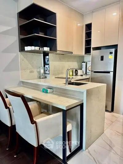 Modern kitchen with sleek design, featuring marble countertops, built-in appliances, and stylish seating.