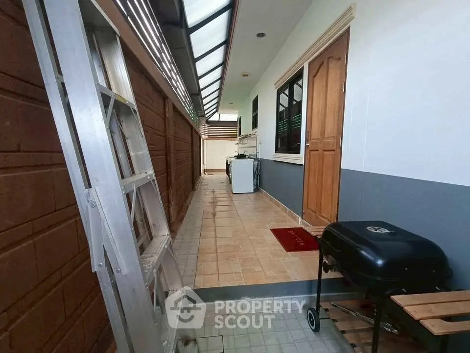 Charming outdoor corridor with BBQ grill and laundry area, perfect for entertaining and relaxation.