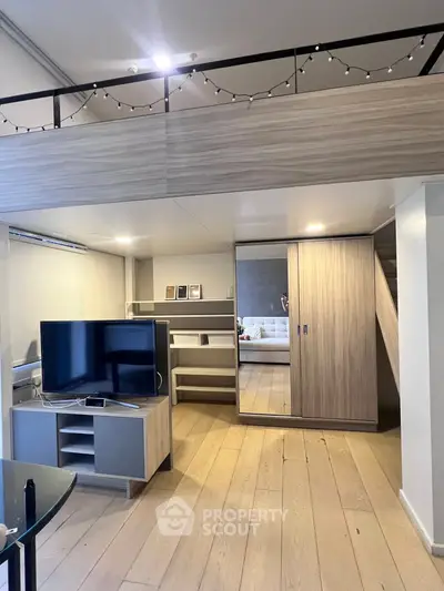 Modern loft apartment with stylish wooden flooring and sleek furniture, featuring a cozy mezzanine level.