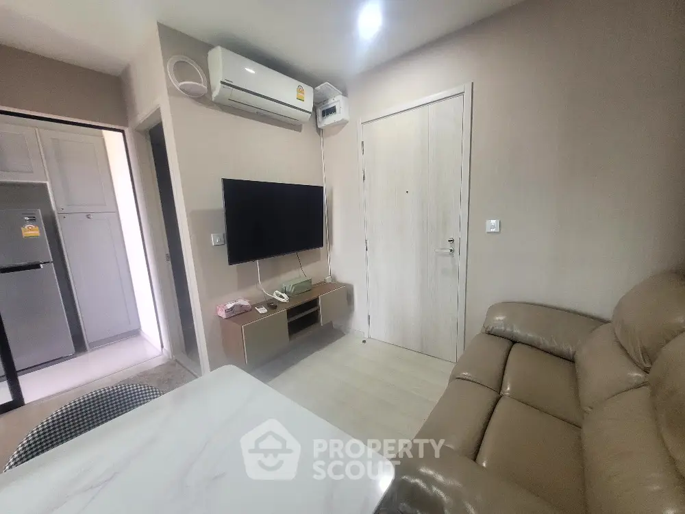 Modern living room with sleek furniture and wall-mounted TV in cozy apartment