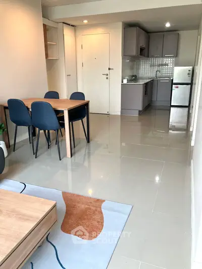 Modern open-plan living room with dining area and sleek kitchen design.