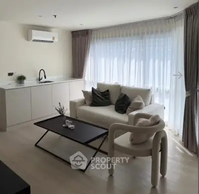 Modern living room with sleek furniture and large window, perfect for natural light lovers.