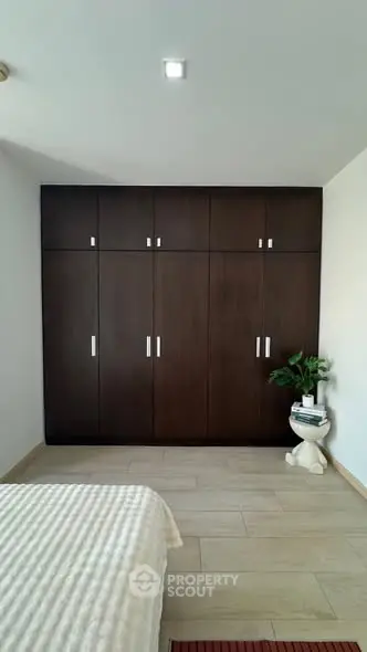 Spacious bedroom with elegant wooden wardrobe and cozy decor