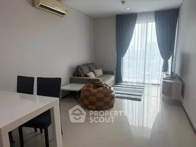 Modern living room with sleek furniture and large window offering city view.