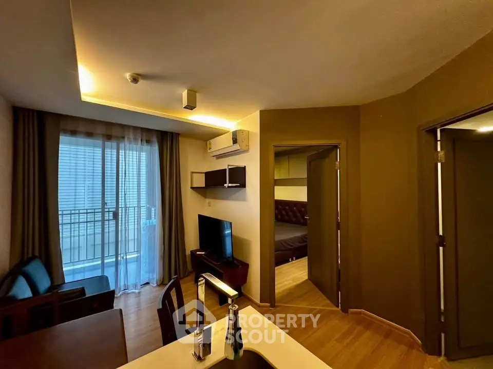 Modern apartment interior with open layout, featuring a cozy living area and a glimpse of the bedroom.