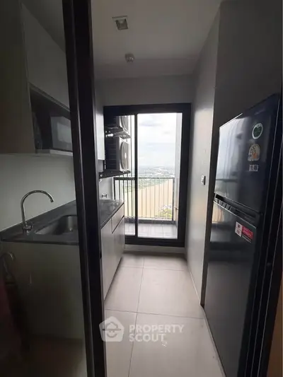 Modern kitchen with sleek appliances and balcony view, perfect for urban living.