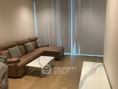 Modern living room with leather sofa and marble coffee table, featuring sleek vertical blinds.