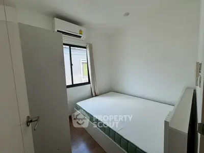 Cozy minimalist bedroom with air conditioning and natural light.