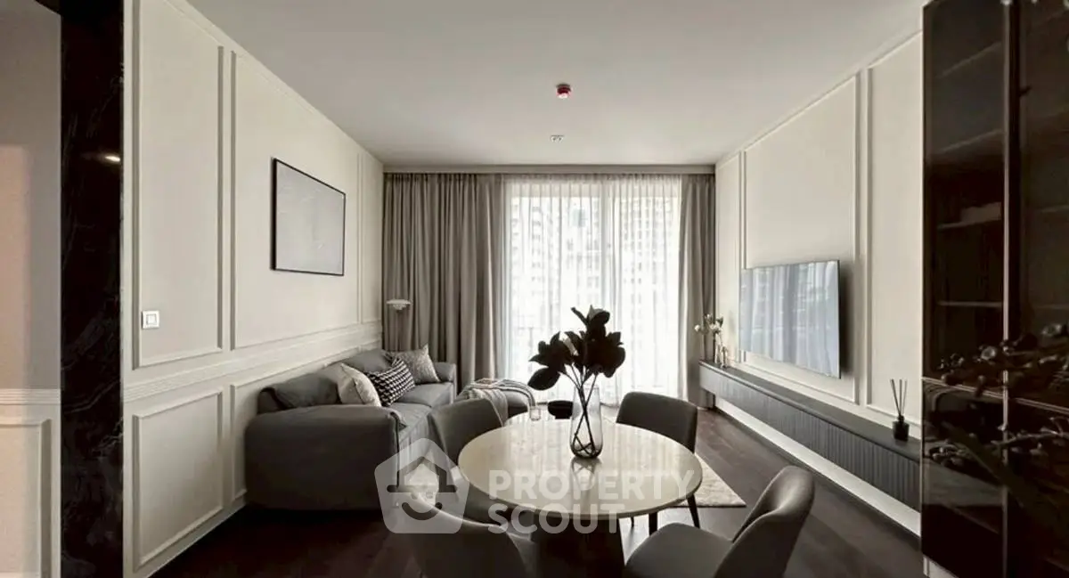 Elegant living room with modern furniture and large window, perfect for relaxation.