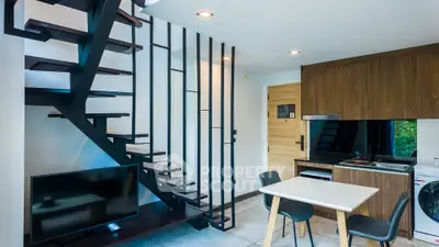 Modern duplex living room with stylish staircase and compact kitchen