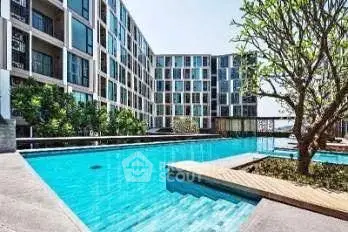 Modern apartment complex with a stunning outdoor pool and lush greenery.