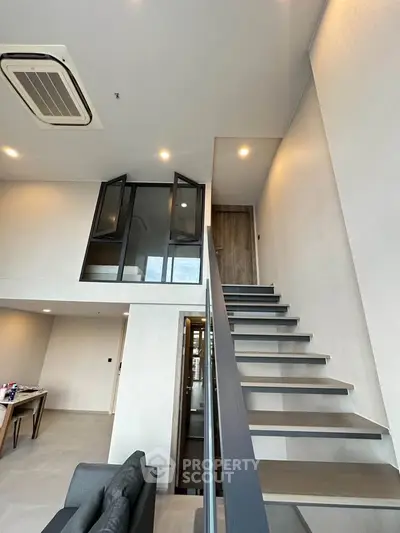 Modern loft apartment with sleek staircase and high ceilings