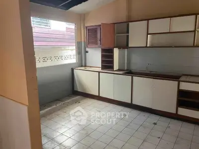 Spacious kitchen with ample cabinetry and natural light, ideal for renovation.