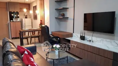 Modern living room with stylish decor, open kitchen, and wall-mounted TV in a cozy apartment.