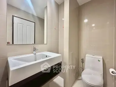 Modern bathroom with sleek sink and toilet in neutral tones