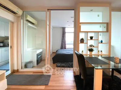 Modern studio apartment with glass partition, cozy bedroom, and stylish dining area.