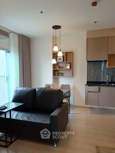 Modern living room with sleek furniture and open kitchen layout in a stylish apartment.