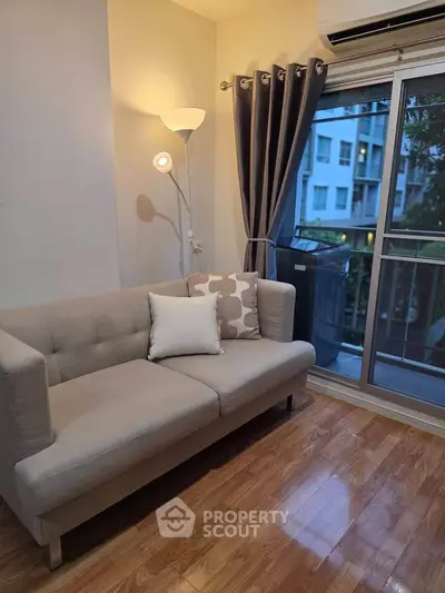 Cozy living room with modern sofa and balcony view in urban apartment