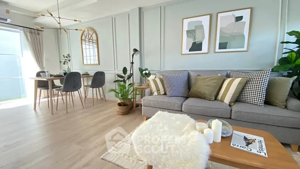 Stylish modern living room with elegant decor and dining area, featuring cozy seating and contemporary artwork.