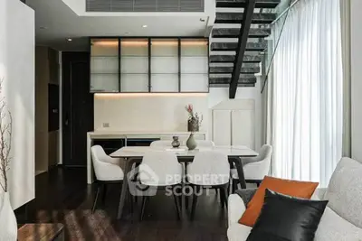 Modern living room with elegant dining area and stylish staircase