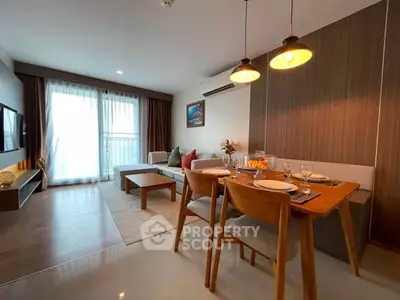 Modern living room with dining area, stylish decor, and natural light from large windows.