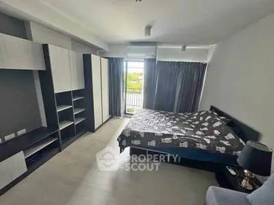 Spacious bedroom with modern furnishings and large window offering natural light and scenic view.