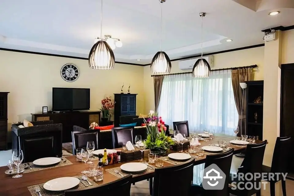 Elegant dining area seamlessly connects to a cozy living space, featuring chic lighting, sophisticated decor, and a welcoming ambiance perfect for entertaining guests.