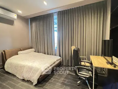 Modern bedroom with sleek design and workspace, featuring a comfortable bed and stylish desk.