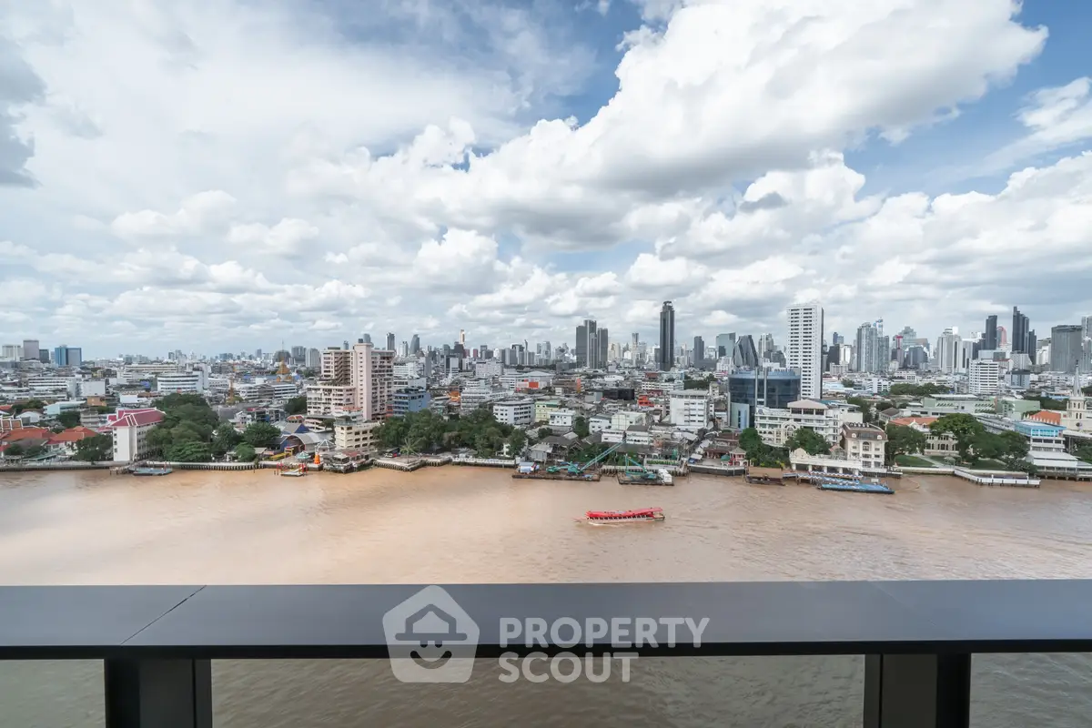 Stunning cityscape view from high-rise balcony overlooking river and skyline.
