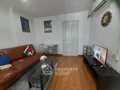 Cozy living room with modern furniture and wall art, featuring a comfortable sofa and flat-screen TV.