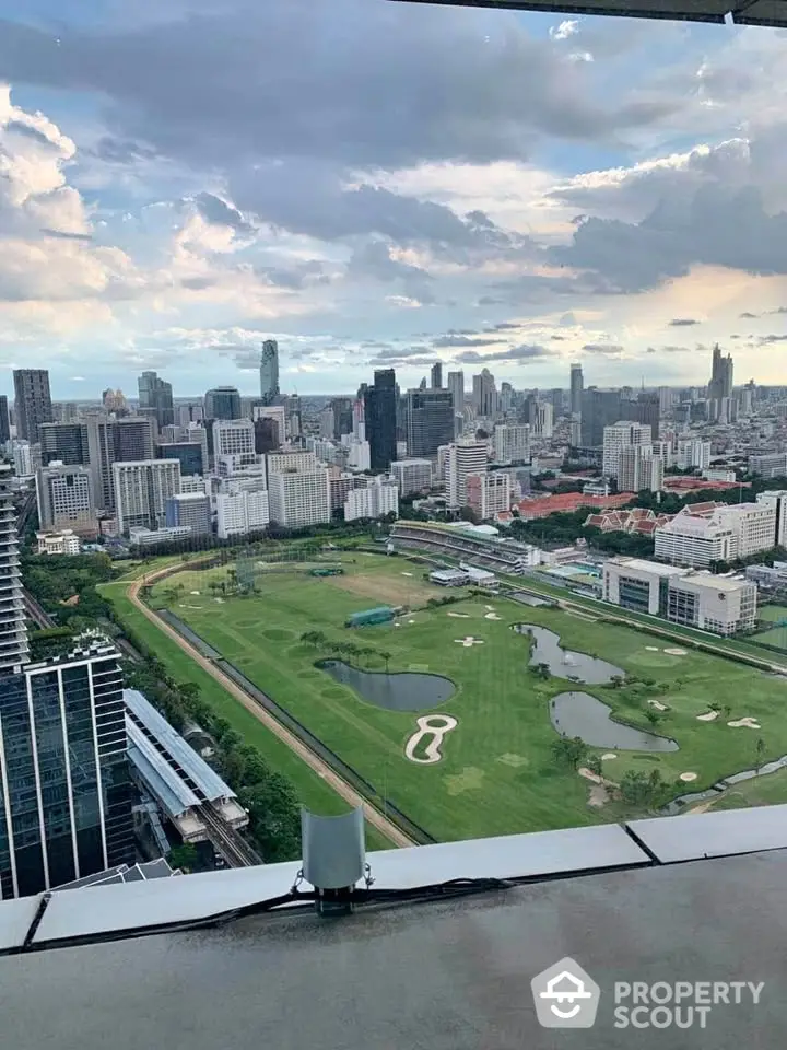 Stunning cityscape view from high-rise building overlooking golf course and skyline.