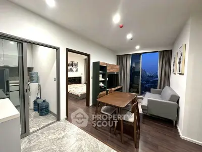 Modern apartment interior with open living and dining area, featuring a city view from the window.