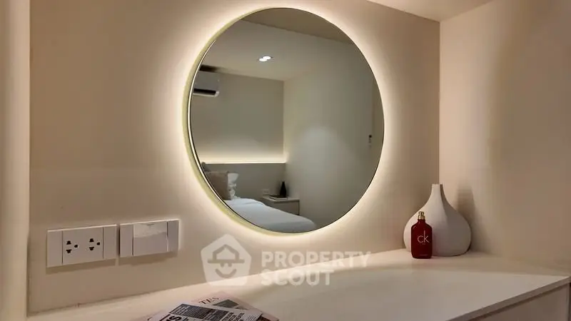Modern bedroom with round backlit mirror and minimalist decor