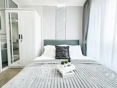 Modern bedroom with stylish decor and natural light, featuring a cozy bed and elegant furnishings.