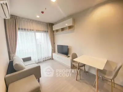 Modern living room with natural light, cozy sofa, and dining area in a stylish apartment.