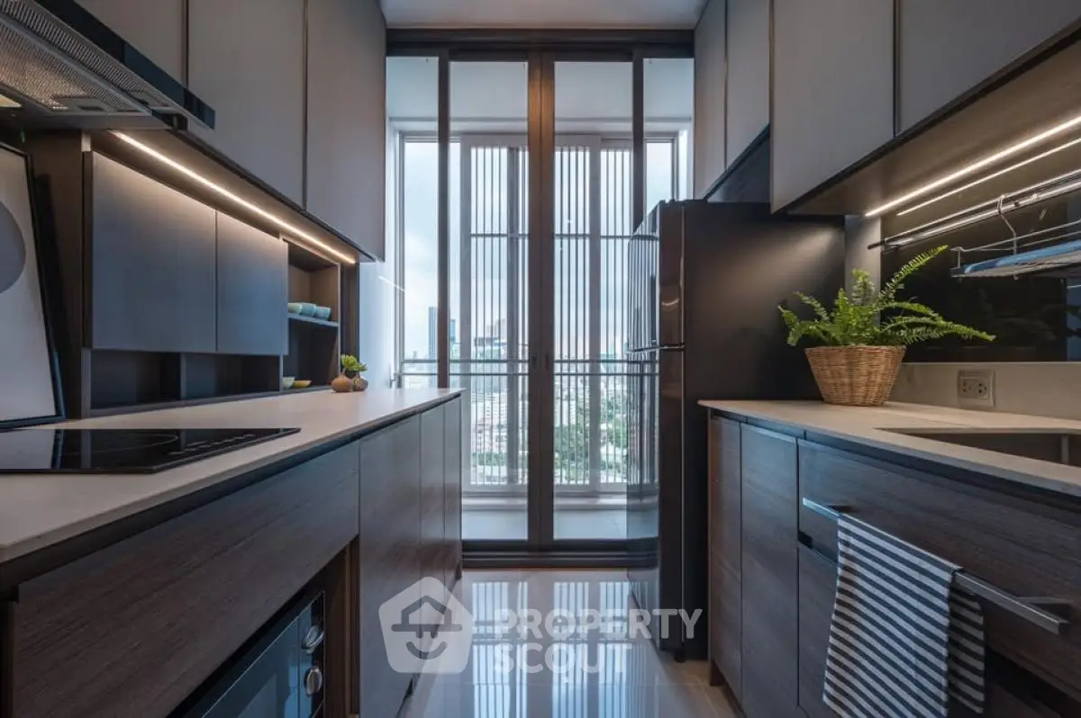 Modern kitchen with sleek cabinetry and large windows offering city views.