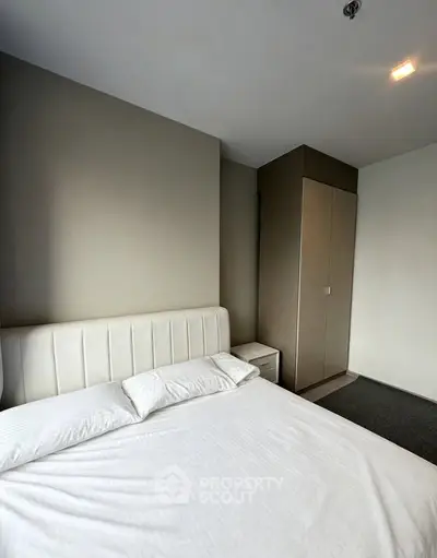 Modern bedroom with sleek design and cozy ambiance, featuring a comfortable bed and built-in wardrobe.