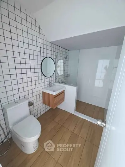 Modern bathroom with sleek design, featuring a glass shower and stylish vanity.