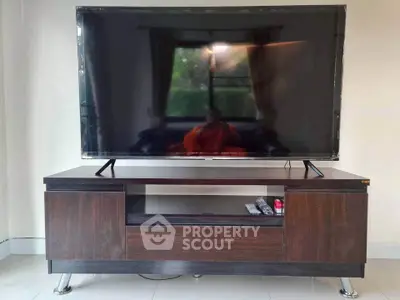 Modern living room with sleek TV stand and large flat-screen TV, perfect for entertainment.