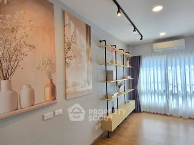 Modern living room with stylish shelving and elegant wall art, featuring natural light and sleek design.