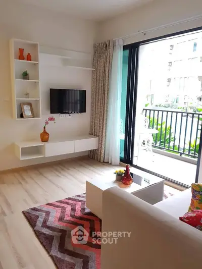 Modern living room with balcony view, featuring stylish decor and natural light.