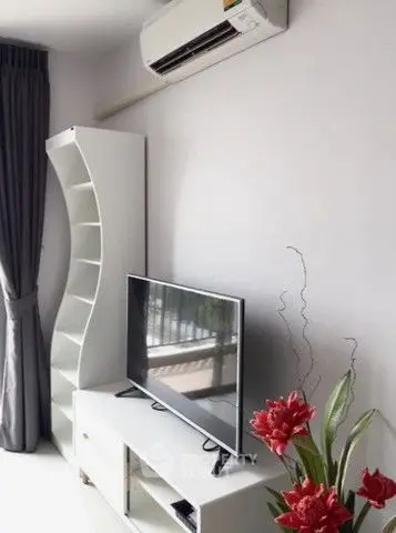 Modern living room with sleek TV stand, air conditioning, and stylish decor.