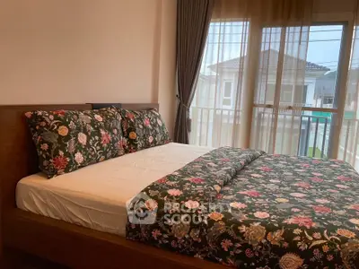 Cozy bedroom with floral bedding and large window view in modern home.